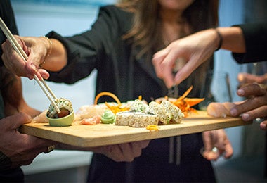 Varias personas disfrutando diferentes rollos en el Día Internacional del Sushi