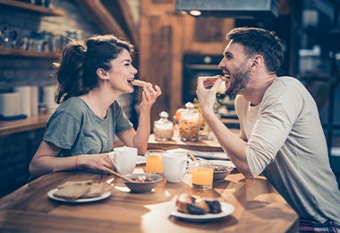 Pareja comiendo sándwiches, uno de los desayunos fáciles y rápidosa