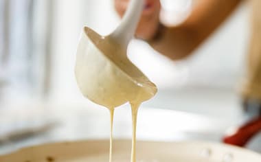 Una mujer preparando panqueques con un cucharón Una mujer preparando panqueques con un cucharón