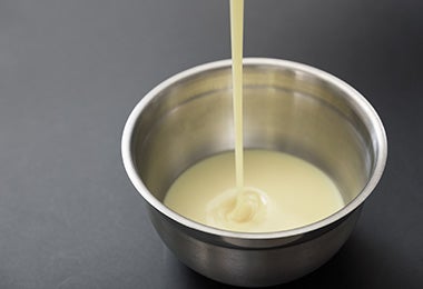 Agregar leche condensada en recipiente para usar en recetas