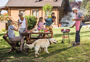 Familia multigeneracional compartiendo una barbacoa al aire libre mostrando una buena alimentación en el adulto mayor
