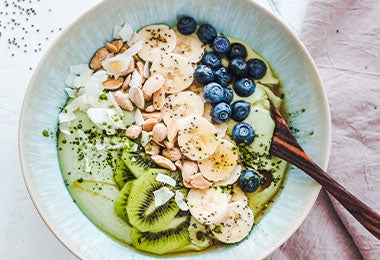 Smoothie bowl con frutas frescas, semillas y granola, como muestra de alimentación saludable y no saludable