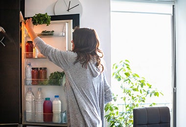 Mujer guardando alimentos en refrigerador, verduras que se pueden congelar 