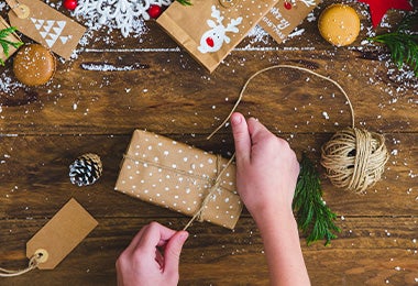 Una persona envolviendo un regalo de Navidad.