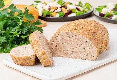 Carne de pavo como parte de los alimentos ultraprocesados, rebanada y servida sobre una tabla de cortar blanca