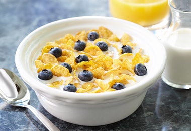 Cereal, fruta, leche y jugo de naranja, una mezcla de diferentes tipos de carbohidratos