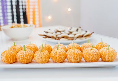 Mandarinas decoradas como calabazas para una fiesta de Halloween. 