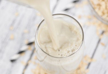 Leche de avena en un vaso, una alternativa vegana para remplazar la leche de origen animal. 