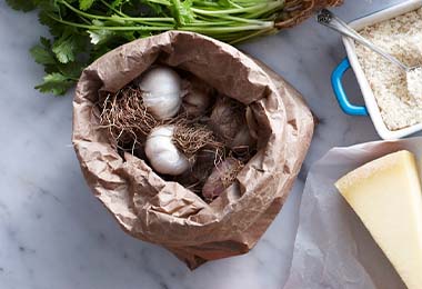 Ajos frescos guardados en una bolsa, al lado de otros ingredientes.