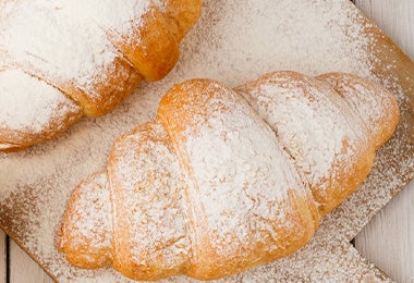 Un croissant con azúcar pulverizada.