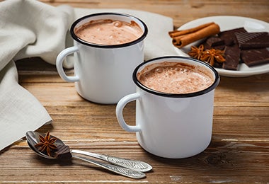 Dos tazas de chocolate caliente con canela  