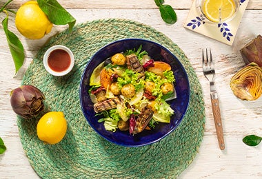 Ensalada fresca en plano cenital con un poco de pasta de tamarindo, limón y un tenedor.