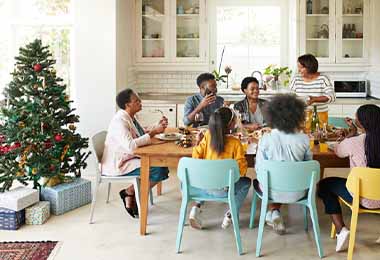 Una familia en un almuerzo de diciembre con guarniciones navideñas.