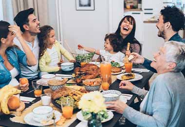 Una familia disfrutando de una cena con guarniciones navideñas.