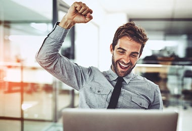 Un hombre celebrando un logro en el trabajo gracias a dejar de procrastinar