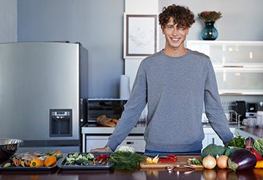 Hombre en cocina con diferentes alimentos, quitar mal olor de la nevera