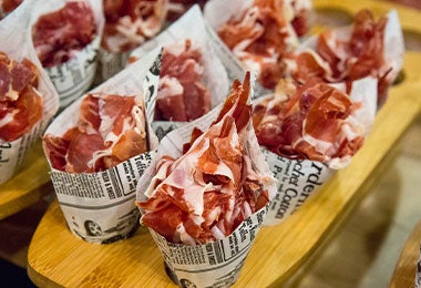 Conos de papel con lonchas de jamón serrano como representación de los alimentos ultraprocesados