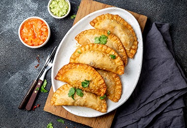 Empanadas fritas con salsas, una preparación que suele estar en los libros de cocina. 