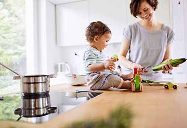 Una mujer y su hijo al lado de una cocina a inducción