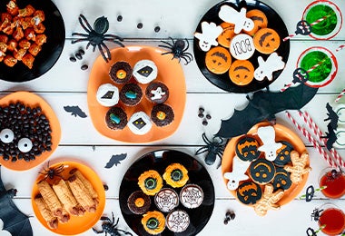 Mesa de dulces y postres con decoración temática de Halloween 