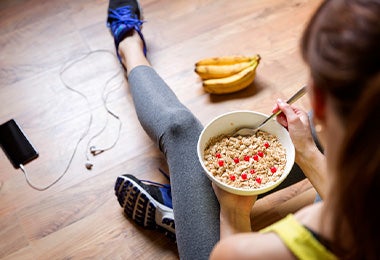 Mujer comiendo avena y banano antes de hacer ejercicio