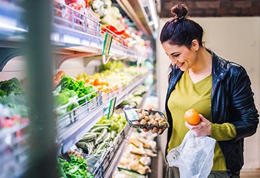 Mujer comprando champiñones y frutas supermercado clasificación alimentos    