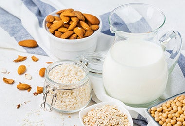 Nueces, leche, granola y otros granos con diferentes tipos de nutrientes.