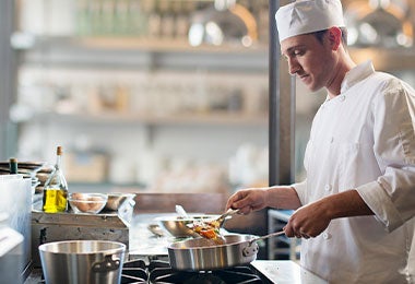 Chef cocinando en ollas de aluminio.