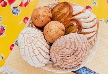Pan dulce y conchas, tipos de pan mexicanos en toma cenital con muffins y corazones