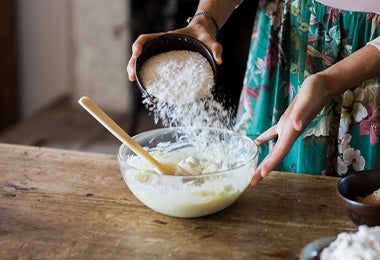 Una mujer preparando la masa de un pan sin gluten. 