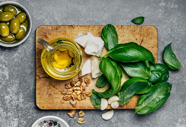 Albahaca, aceite de oliva, ajo y los demás ingredientes necesarios para preparar pasta pesto