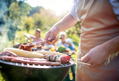 Persona cocinando en asador de gas 