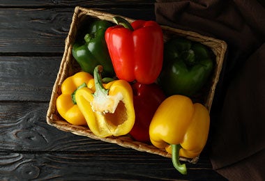 Caja de pimientos verdes, amarillos y rojo.