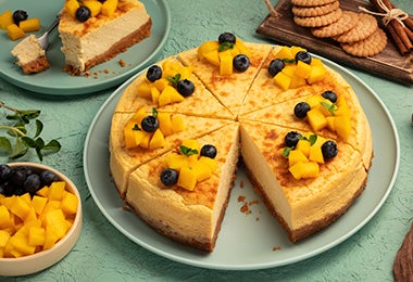  Un pie de mango con base de galletas y decorado con frutas. 