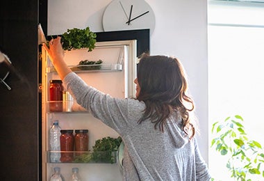 Mujer sacando ingrediente de refrigerador, quitar mal olor de la nevera