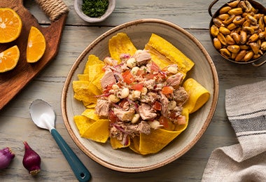 Una receta de ceviche con atún, verduras y chips de plátano.