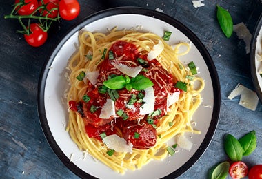 Espagueti con salsa pomodoro, queso rallado y hierbas aromáticas. 