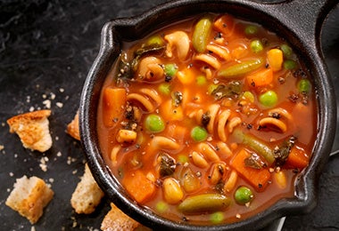  Sopa de pasta y verduras preparada en una olla de hierro. 