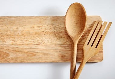 Tabla con tenedor y cucharón de madera 