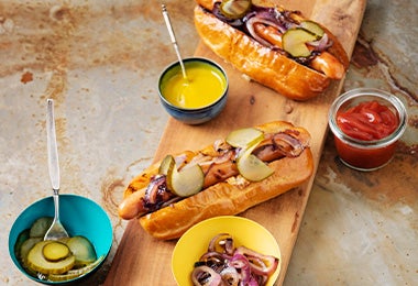 Tabla con hot dogs con salsas kétchup y mostaza  