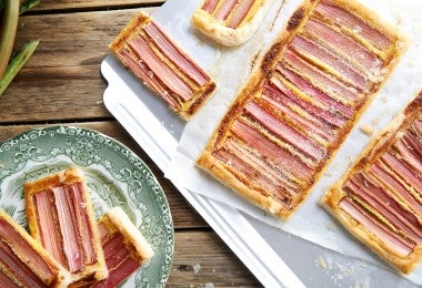 Tarta de ruibarbo con tiras rosadas alineadas, servida en una bandeja