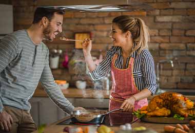 Una pareja probando qué tan salado quedó su plato.