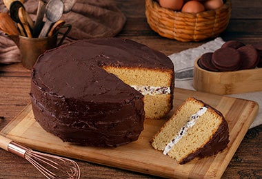 Mesa con torta de cumpleaños de vainilla con cobertura de chocolate 