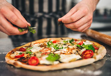 Una pizza italiana tradicional con verduras y queso, un atractivo del turismo gastronómico. 