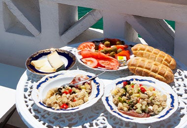 Una mesa con dos platos servidos y con vista al mar, una posibilidad del turismo gastronómico