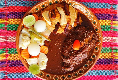 Un plato de mole con pollo y ensalada, muy famoso en el turismo gastronómico de México. 