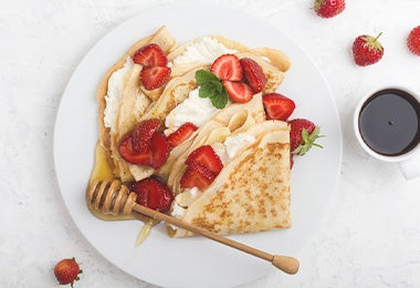 Waffle con fresas, crema, miel y hierbabuena, una comida con calorías que puedes consumir