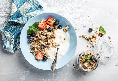 Plato de yogurt griego con granola y frutas para el desayuno 