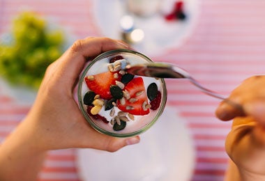 Primer plano de un vaso de yogurt con fresas y semillas, una combinación práctica y deliciosa que suma alimentos con omega 3 para un desayuno o merienda nutritiva