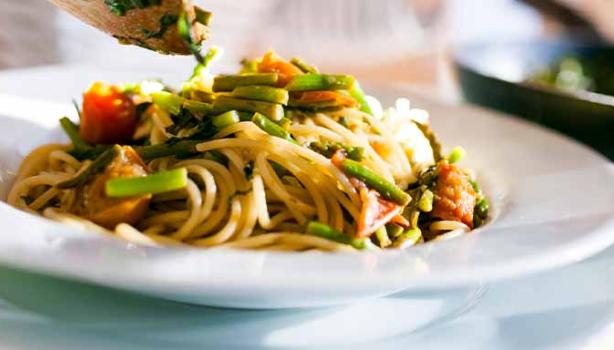 Una pasta italiana acompañada de verduras.